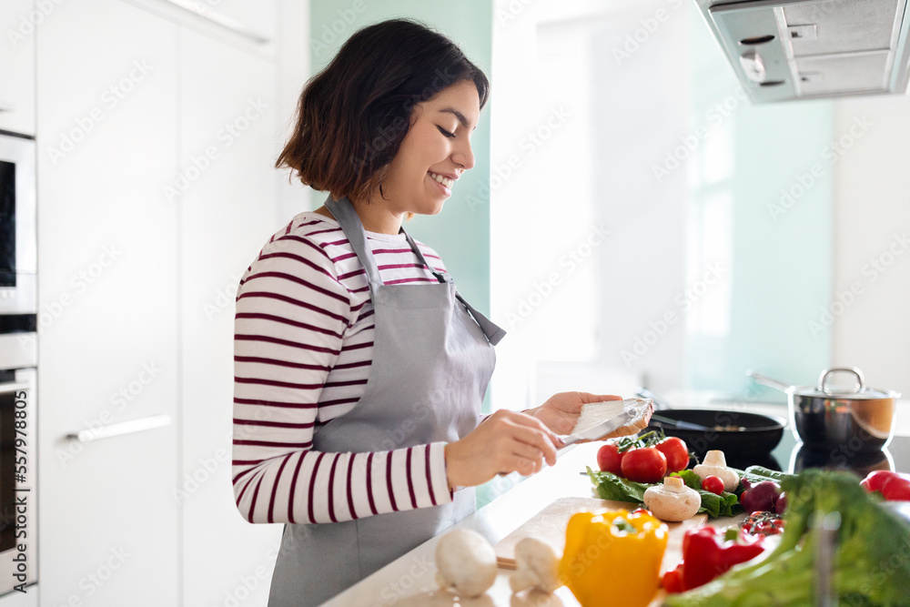 Young woman housewife making breakfast for family