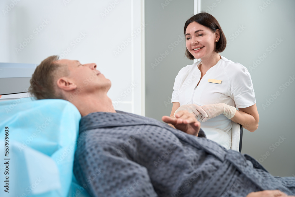 Obraz premium Friendly medical personnel interacting with man in chair