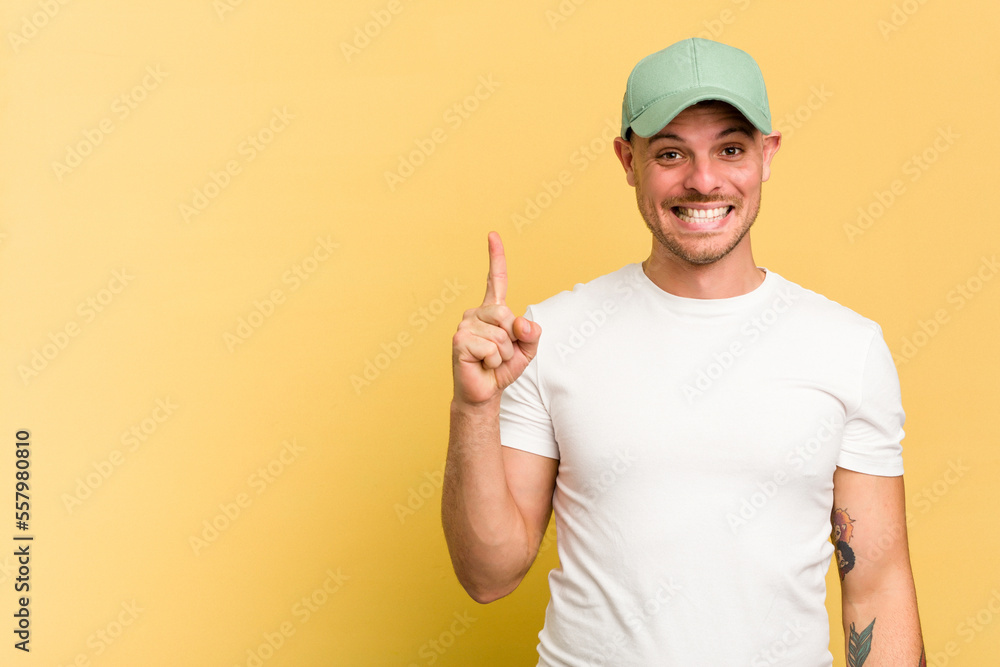 Young caucasian handsome man isolated on yellow background showing number one with finger. Young caucasian handsome man isolated on yellow background showing number one with finger.