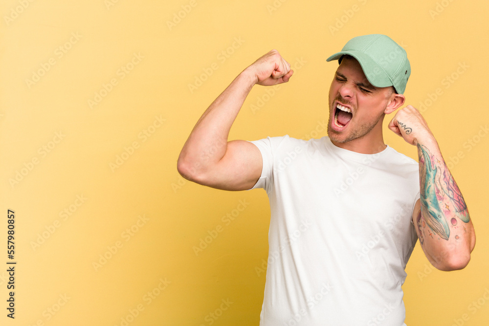 Young caucasian handsome man isolated on yellow background raising fist after a victory, winner concept.