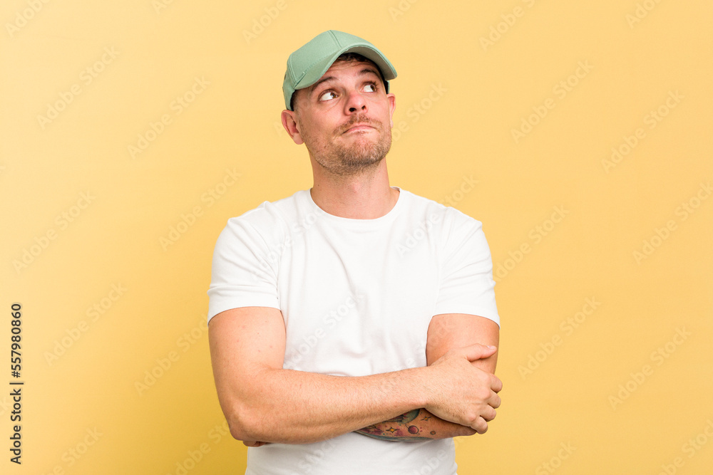 Young caucasian handsome man isolated on yellow background dreaming of achieving goals and purposes