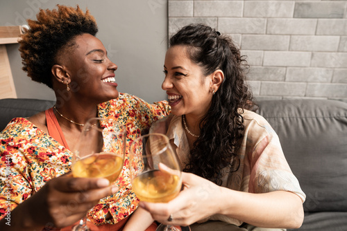 Happy same-sex couple have fun at the weekend on the sofa in the living room at home