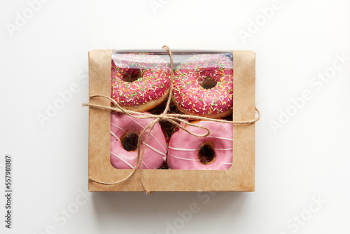 Pink donuts packed in box isolated on white background, natural light photo