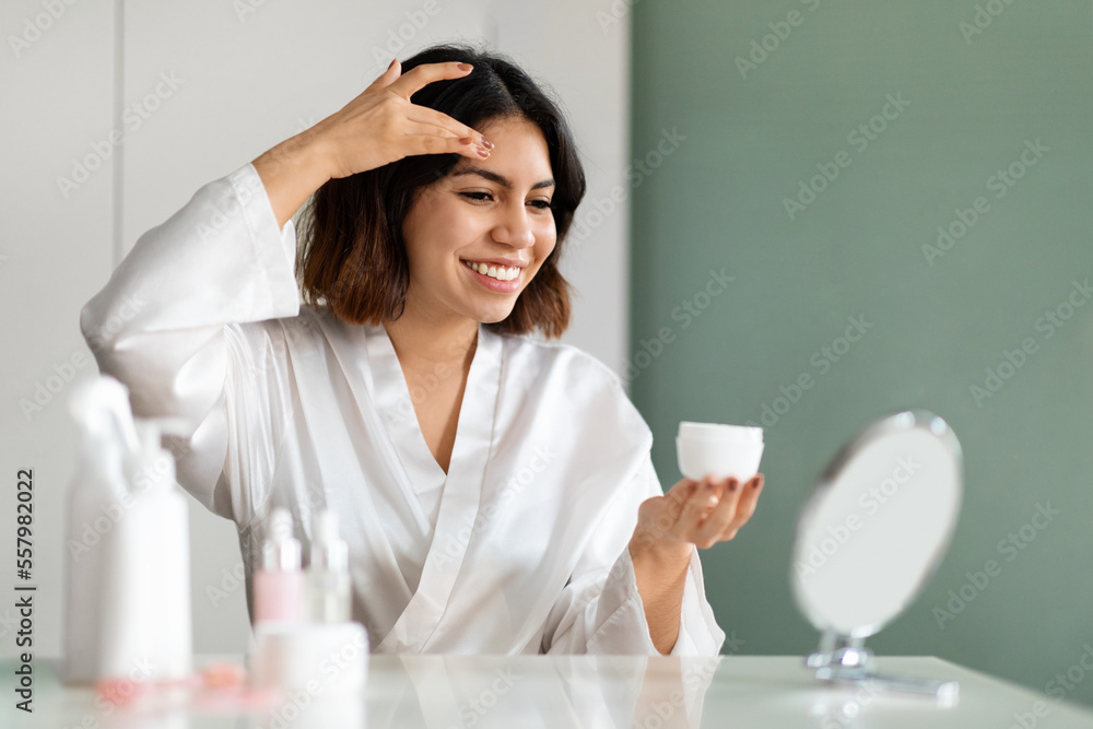 Beautiful woman using new cosmetic at home, copy space Beautiful woman using new cosmetic at home, copy space