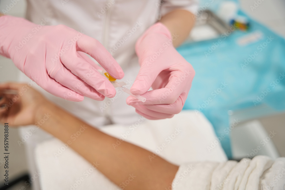 Cosmetologist getting ready to take blood test Cosmetologist getting ready to take blood test