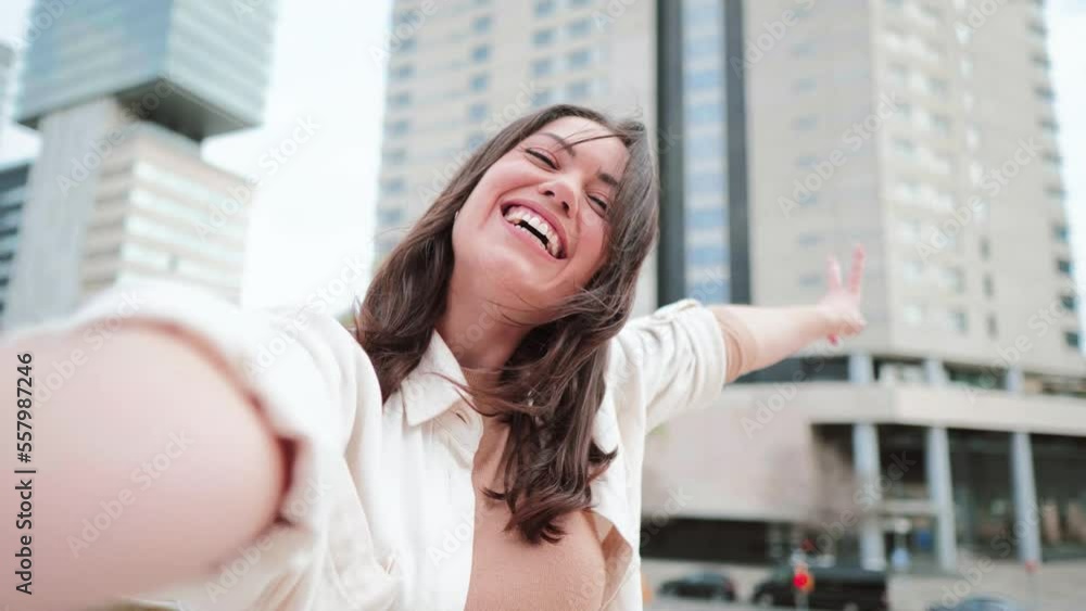 Pretty young female with big smile having fun taking cheerful selfie in the city. Image of happy woman isolated make picture with camera. High quality 4k footage Pretty young female with big smile having fun taking cheerful selfie in the city. Image of happy woman isolated make picture with camera. High quality 4k footage
