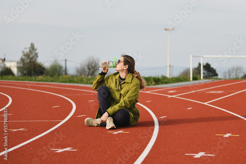 A woman drinking water at the stadium