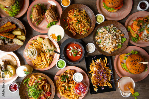 Abundance snack and fast food on wooden table in restaurant. New restaurant menu and alcohol drinks in cafe. Full frame