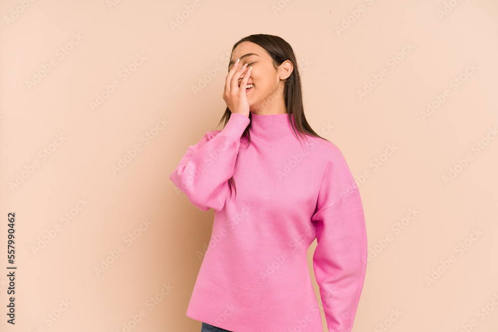 Young colombian woman isolated on beige background laughing happy, carefree, natural emotion. Young colombian woman isolated on beige background laughing happy, carefree, natural emotion.