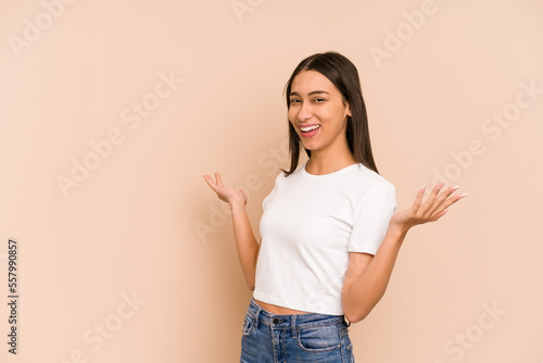 Young colombian woman isolated on beige background joyful laughing a lot. Happiness concept.