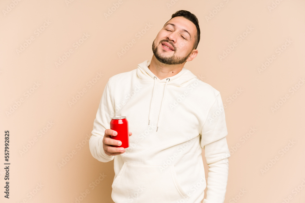 Young latin man holding a cola refreshment isolated dreaming of achieving goals and purposes Young latin man holding a cola refreshment isolated dreaming of achieving goals and purposes