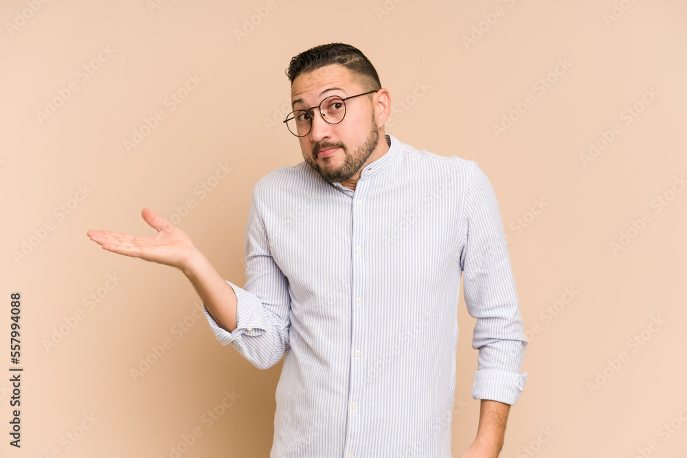 Adult latin man cut out isolated showing a copy space on a palm and holding another hand on waist. Adult latin man cut out isolated showing a copy space on a palm and holding another hand on waist.