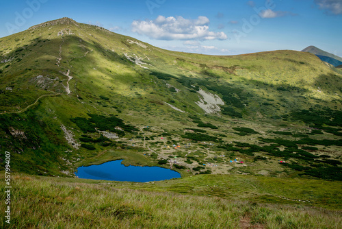 Camp of tourists near impressive mountain lake in the Carpathians. Ukraine. Mountain landscape. View from above