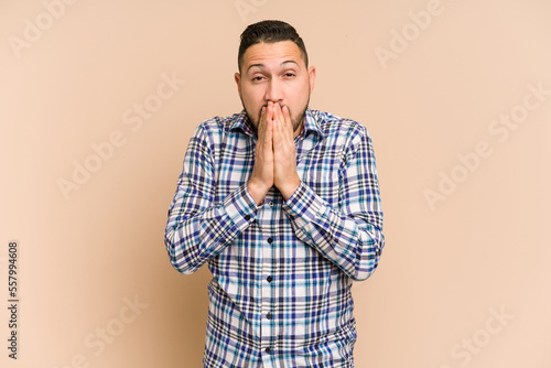 Adult latin man cut out isolated covering mouth with hands looking worried.