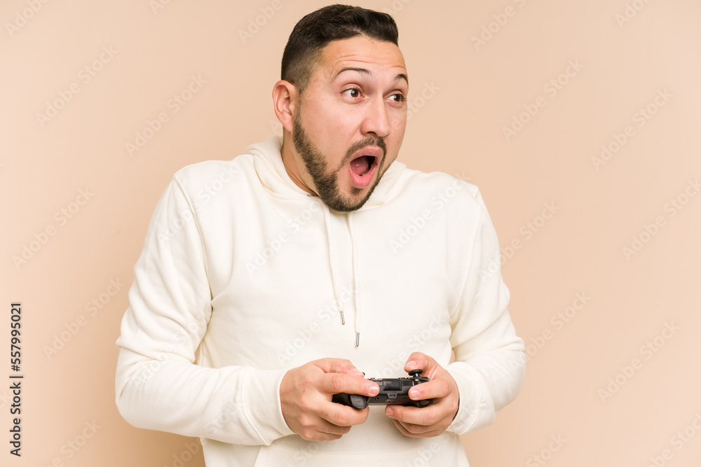 Adult latin man playing with a game controller isolated Adult latin man playing with a game controller isolated