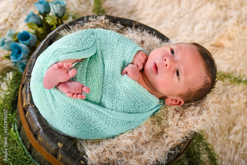 Lindo Bebê recém nascido menino com a boca aberta enrolado no cobertor photo