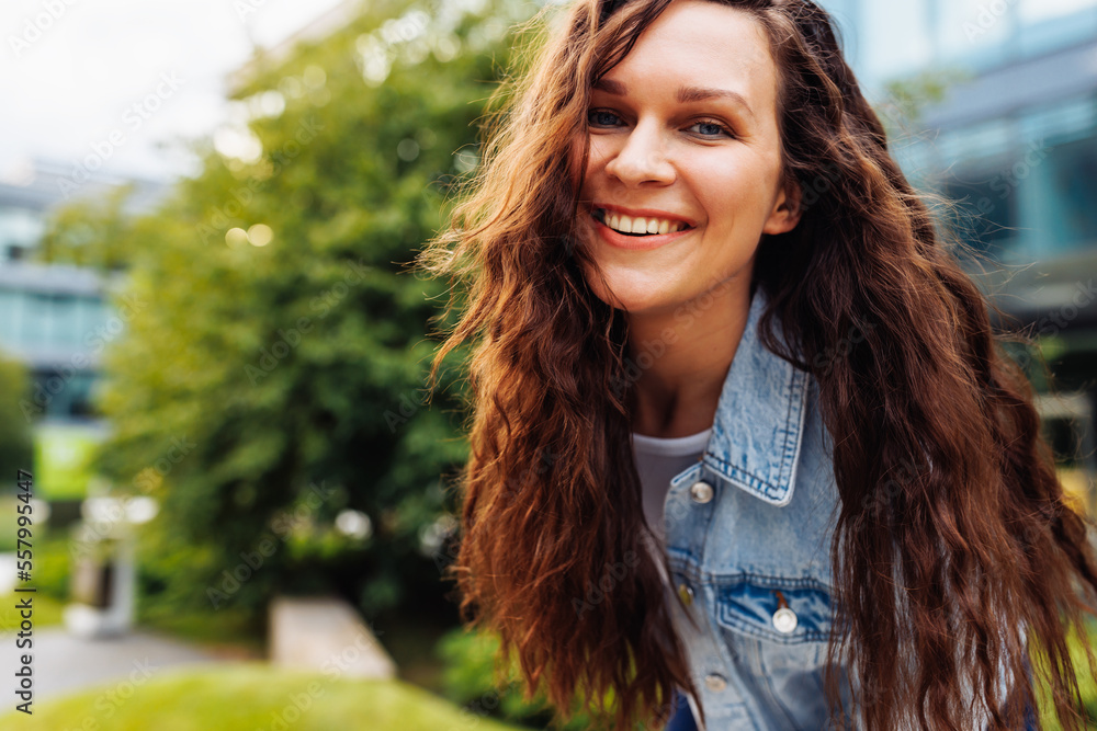 Happy pretty young redhead woman with long curly hair