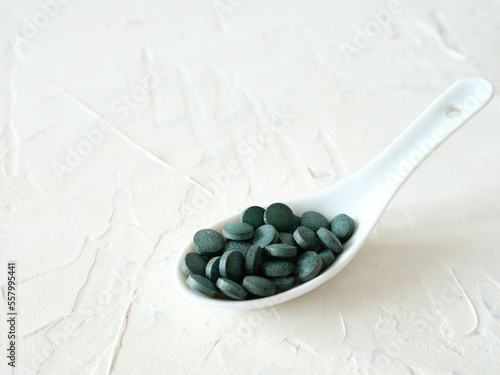 Green algae in pills spirulina on white background superfood