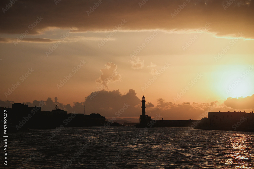 Chania, Greece, view of the old venetian lighthouse in the city harbour at sunset. 