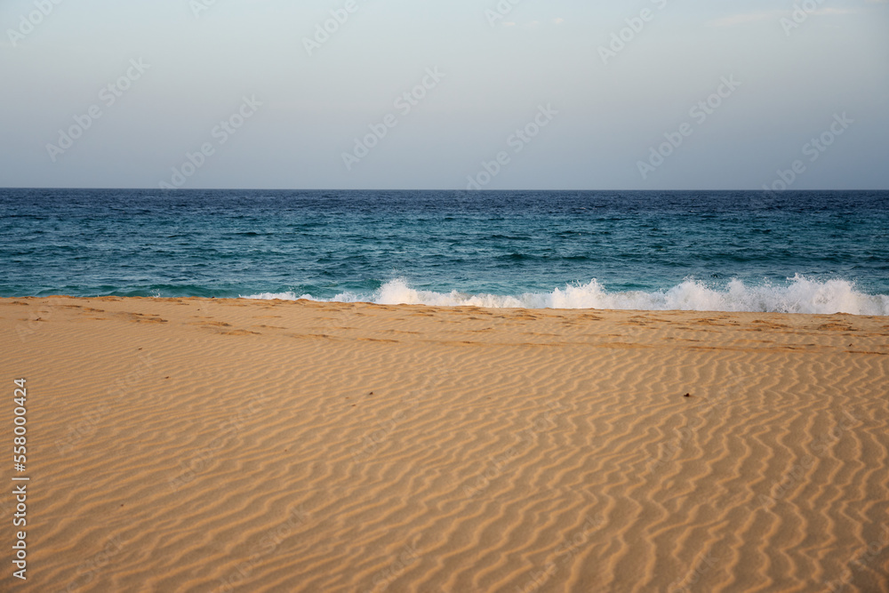 Sand on a beach on the atlantic ocean with a blurred water in the background.