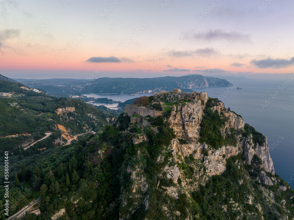 Aerial drone view of iconic medieval fortified castle of Agelokastro with amazing views to Paleokastritsa bay, Corfu Greece
