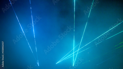 Laser show. Night club, lights, smoke machine. Blue background