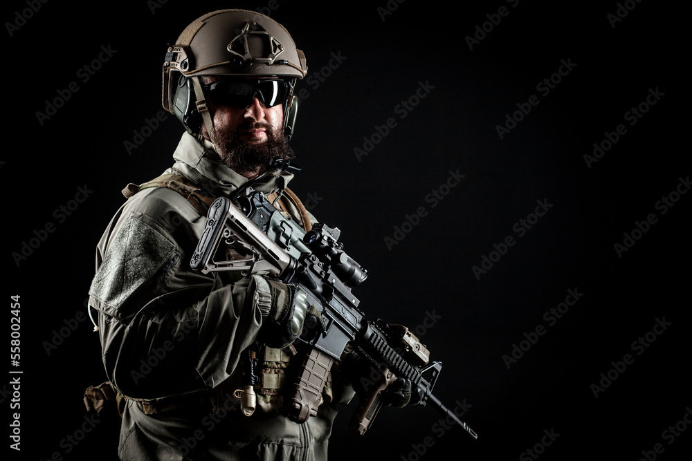American special forces, a soldier in uniform holds a weapon on a black background