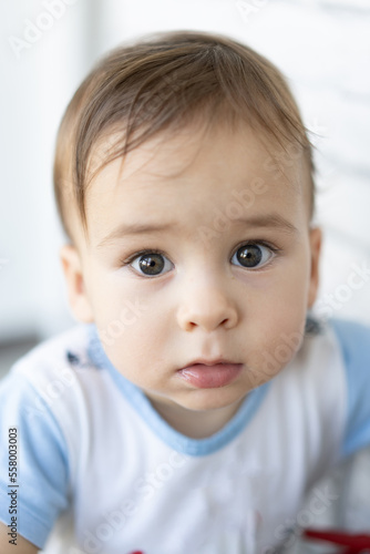 Close-up of sweet little baby face looking at camera. Handsome toddler portrait.