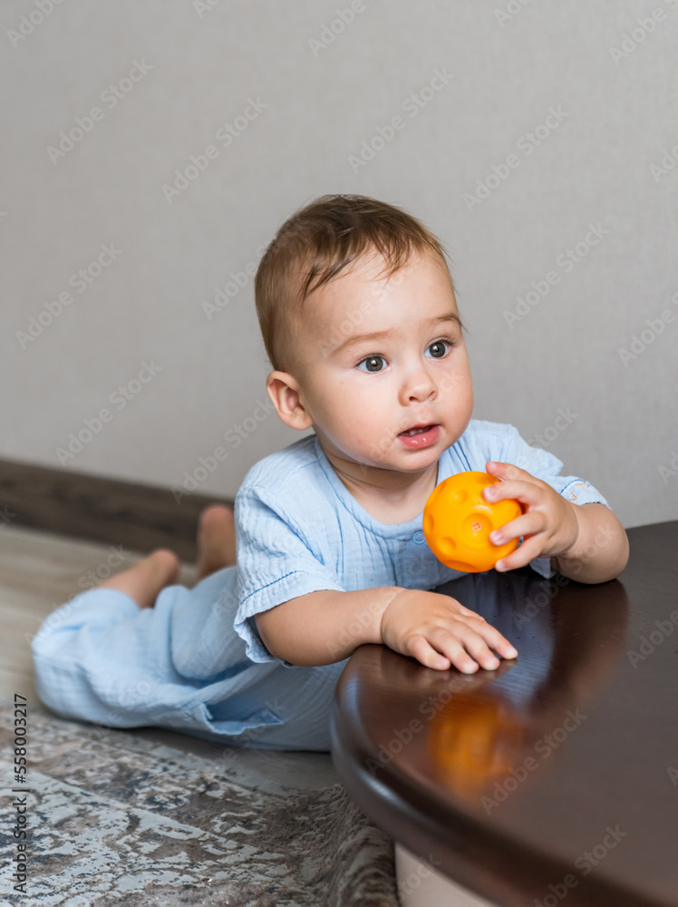 Cute baby playing with ball on the stairs. Baby boy playing with colorful toy. Cute baby playing with ball on the stairs. Baby boy playing with colorful toy.