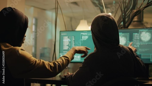 Team of hackers using trojan virus to exploit computer server, hacking network system late at night. Cyber spies working with encryption to hack software and break security firewall. photo
