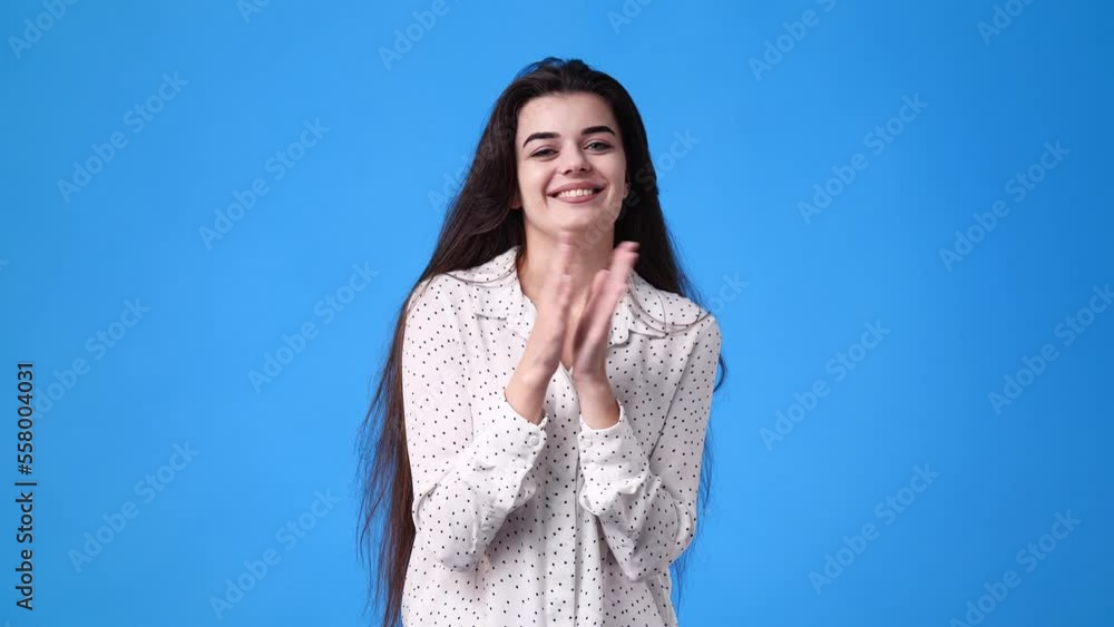 4k video of excited girl clapping in hands on blue background. 4k video of excited girl clapping in hands on blue background.