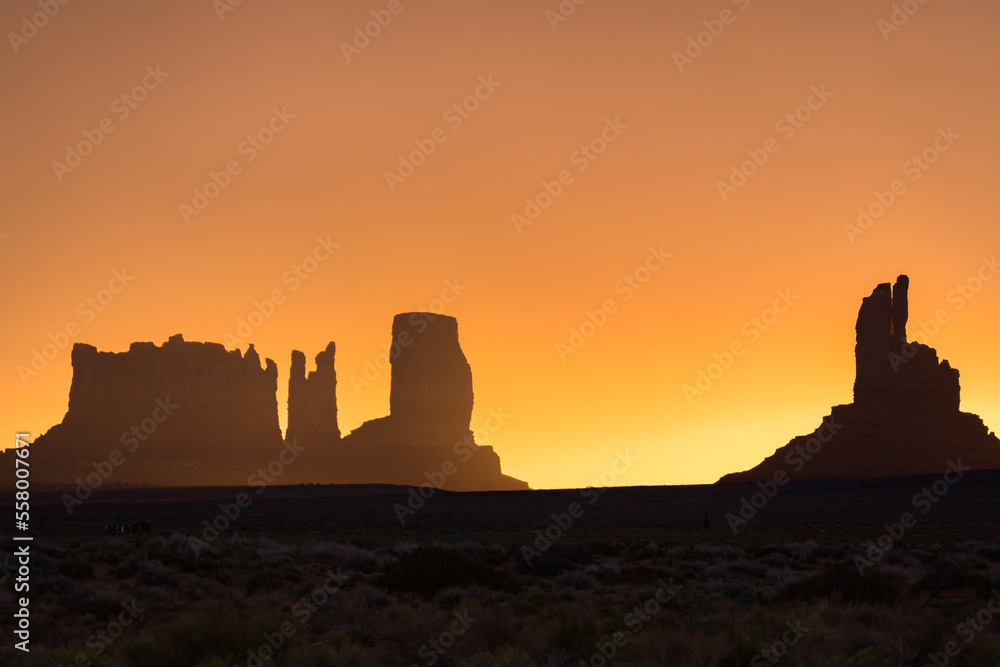 silhouettes of monument valley buttes during sunrise