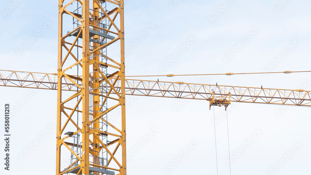 Low-angle view of a construction crane at work on a building site.