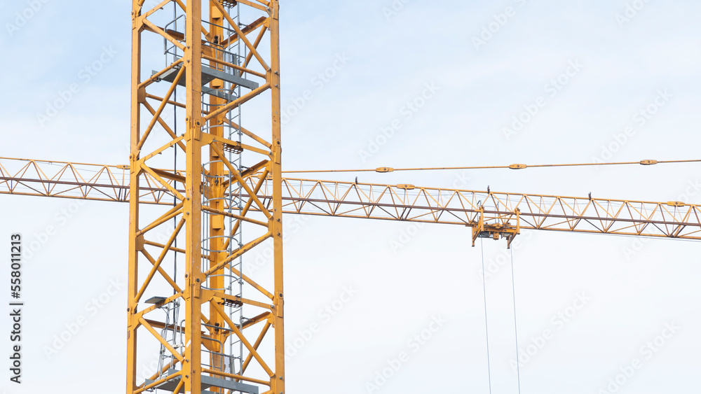 Low-angle view of a construction crane at work on a building site. Low-angle view of a construction crane at work on a building site.