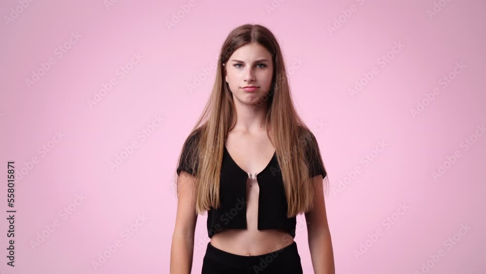 4k video of one girl with crossed hands on pink background. 4k video of one girl with crossed hands on pink background.
