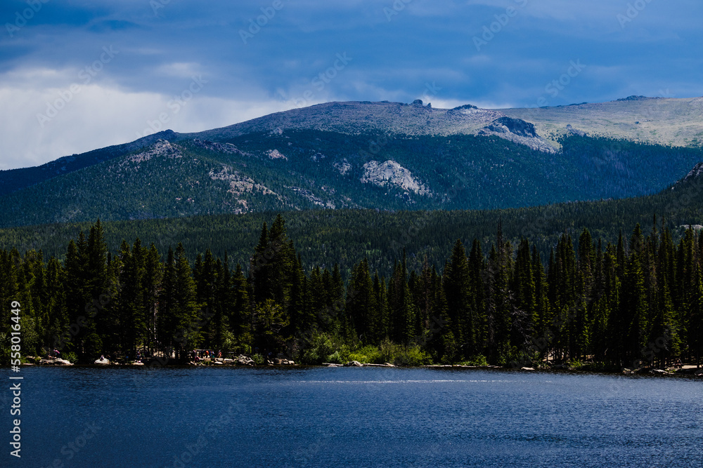 Bear Lake wooded shoreline with the Rocky Mountains in the distance, Colorado 