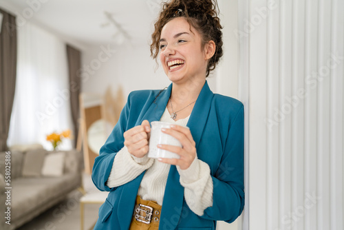 one happy caucasian young woman with cup of coffee at home