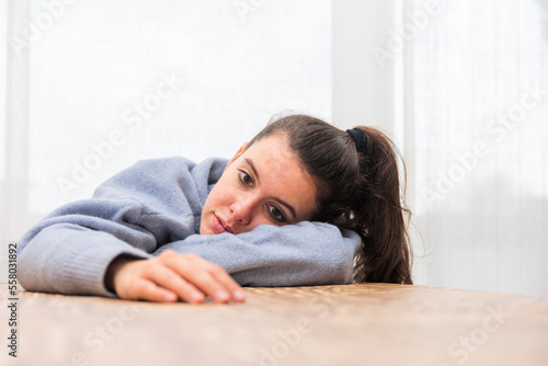 A young adult woman looking bored, being and feeling bored