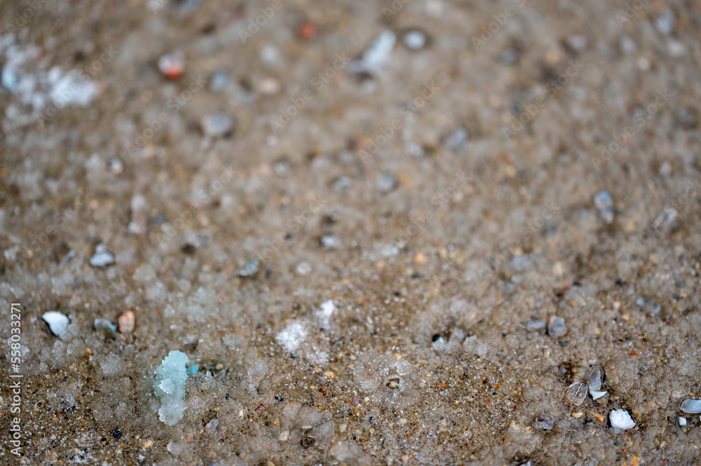 macro ground level closeup view of rock salt ice-melt on concrete with a frozen layer. macro ground level closeup view of rock salt ice-melt on concrete with a frozen layer.