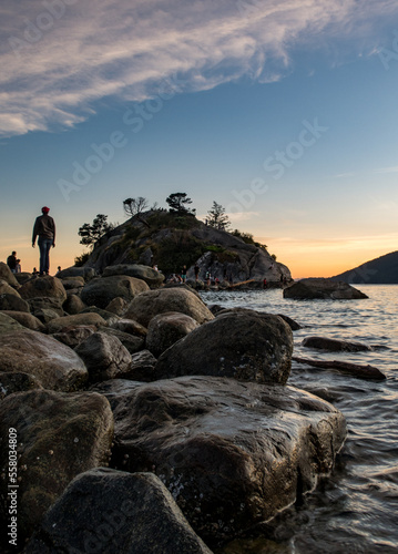 Person walking along a rocky pathway to an island
