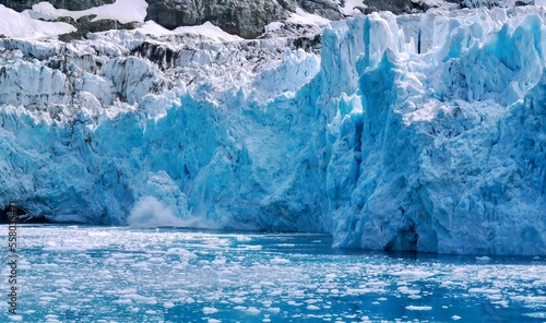 Closeup view of a glacier face as a piece of ice splashes into the water after calving. In Drygalski Fjord on South Georgia Island.