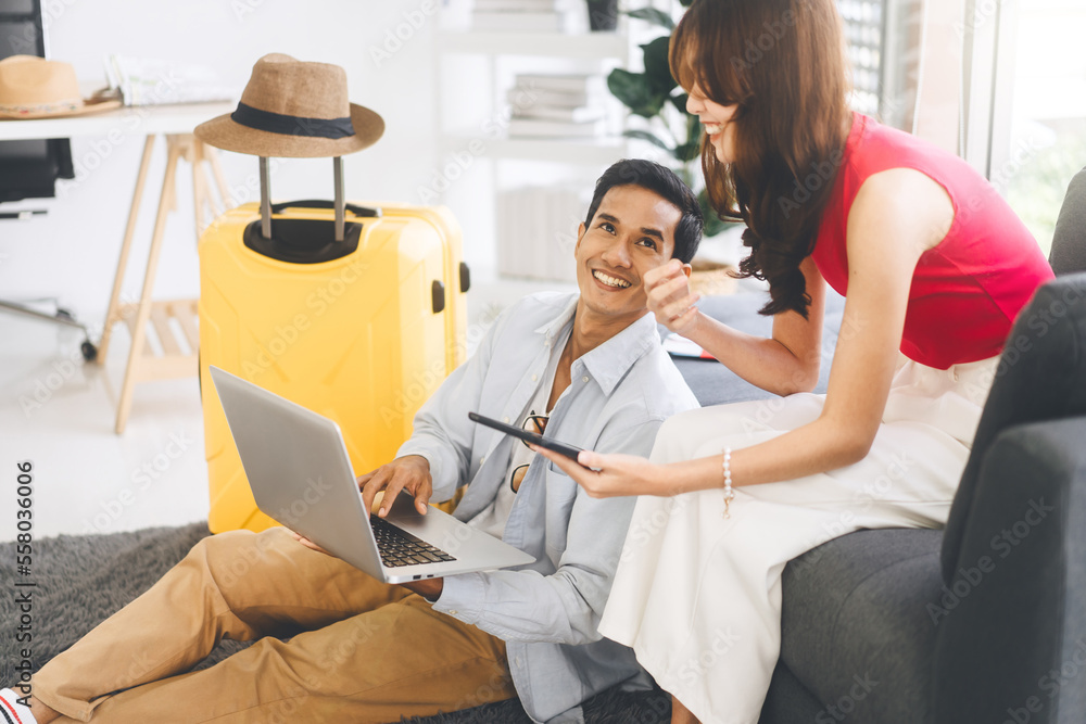 Obraz premium Young adult southeast asian couple using laptop for getting ready for holidays travel trip