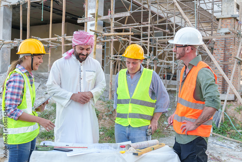 Diverse team of professionals using tablet computers on construction site. Real estate construction project. with civil engineers, architects, Arabic business investors and explorer with theodolite
