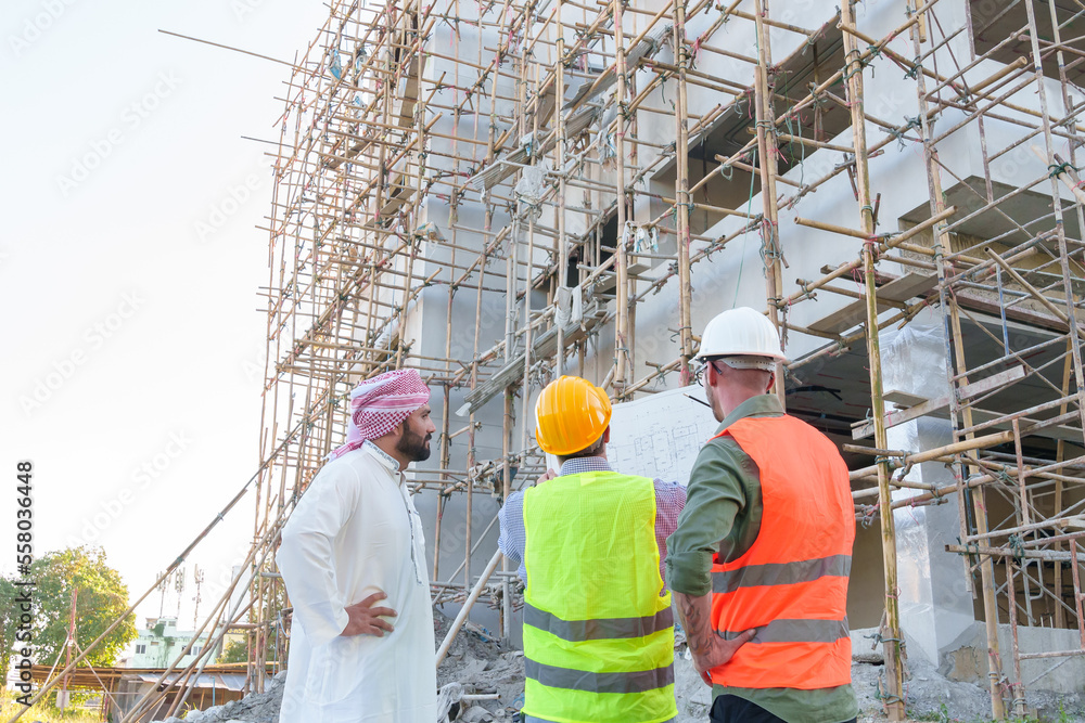 Diverse team of professionals using tablet computers on construction site. Real estate construction project. with civil engineers, architects, Arabic business investors and explorer with theodolite