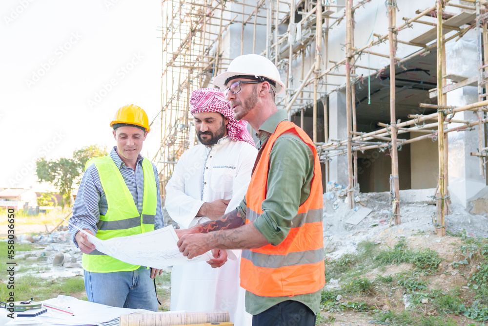 Diverse team of professionals using tablet computers on construction site. Real estate construction project. with civil engineers, architects, Arabic business investors and explorer with theodolite Diverse team of professionals using tablet computers on construction site. Real estate construction project. with civil engineers, architects, Arabic business investors and explorer with theodolite