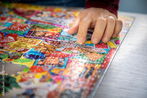 Close up of a hands holding puzzle pieces with others diffused