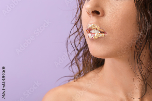 Naked young woman with gold...