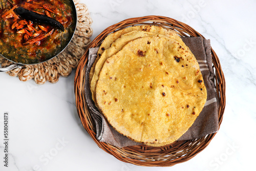 Makki di roti or Corn meal bread and mustard leaves curry. It's a popular Punjabi winter dish made using corn meal. served with onions, green chili, and Sarson ka saag, with copy space. photo