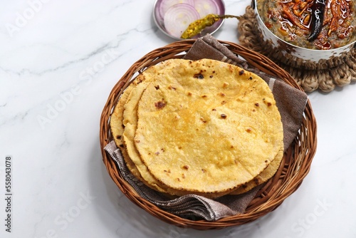 Makki di roti or Corn meal bread and mustard leaves curry. It's a popular Punjabi winter dish made using corn meal. served with onions, green chili, and Sarson ka saag, with copy space.