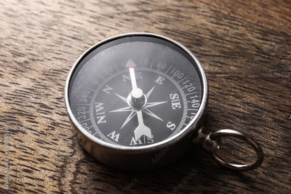 Retro compass on dark wooden background, closeup Retro compass on dark wooden background, closeup